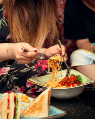 woman eating bolognese spaghetti at the restaurant