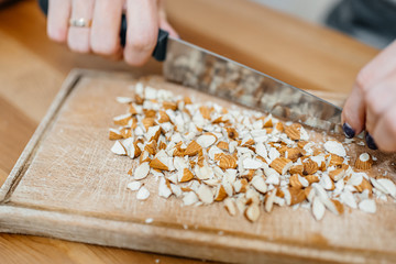 Cook cuts nuts on a wooden board