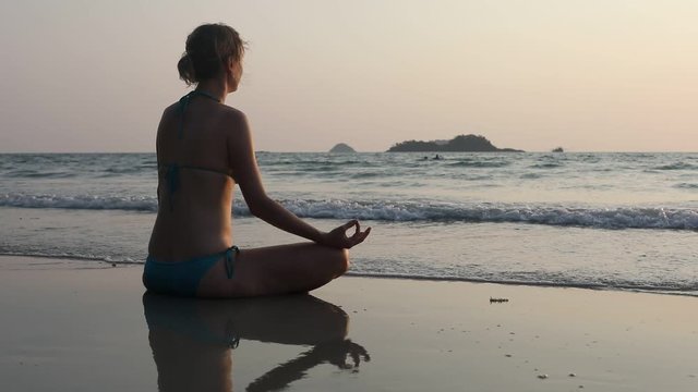 yoga and relaxation, meditation on the beach, silhouette of woman