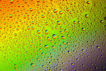 closeup of water droplets on a glass. Rainbow background, colorful abstract pattern.