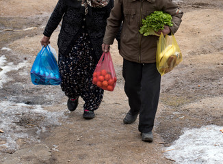 Eskisehir, Turkey - January 21, 2017: The Elderly Turkish Traditional Couple   Carrying Grocery Bags while Coming Back From The Local Bazaar with Their Old Fashioned Traditional Clothes.