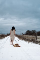 Junge Frau mit Teddybär stehen barfuß im Schnee - 307136706