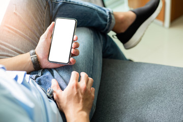 Mockup image blank white screen cell phone.men hand holding texting using mobile on desk at home office. background empty space for advertise text.people contact marketing business and technology 