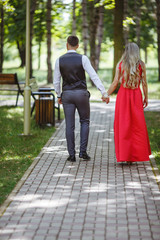 Beautiful and happy couple holding hands in a park.