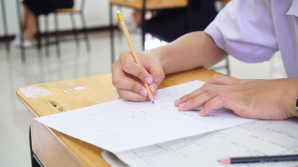 Evaluation or measurement concept. Student testing in exercise taking fill in exam at school or university in test room, writing document exams paper at campus classroom, education back to school idea
