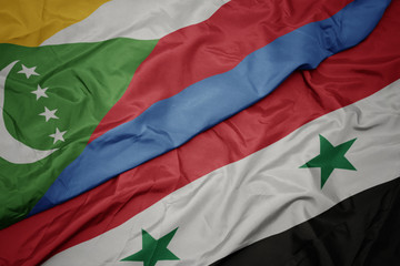 waving colorful flag of syria and national flag of comoros.