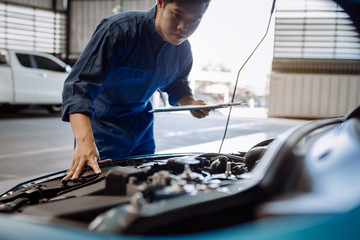 Mechanic man examining and maintenance via insurance system fix the engine a vehicle car hood, Safety inspection before customer drive on a long journey, transportation repair garage service center