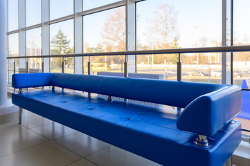 Interior concept of a modern urban building. Photo of a blue sofa in the lobby of a public building.
