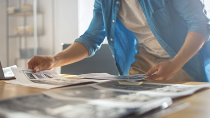 Young Creative Designer Works on a Storyboard, Looks at His Sketches and Concepts, Choosing the Best Drawings for His Project. Video Editing, Comics Compilation, Application UI or Game Plot