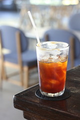 Black coffee with ice on table in cafe.