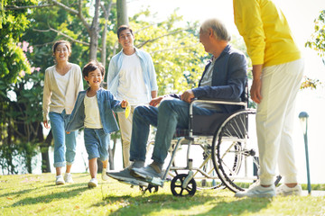 happy three generation asian family having fun in park
