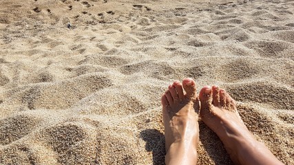 female feet on the beach and sand