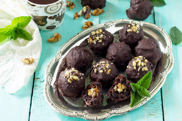 Homemade prune sweets, healthy food. Prune balls in chocolate with hazelnut filling.
