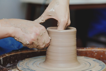 Woman hands on pottery wheel. Craftsman artist shapes pot