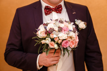 Groom holds a wedding bouquet