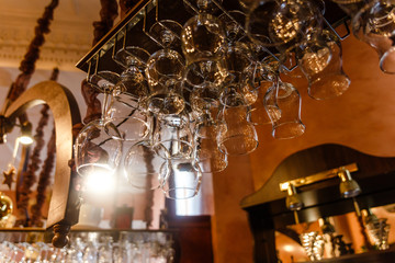 clean glasses hang behind the bar
