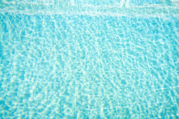 Blurred photo of Top view Swimming pool bottom caustics ripple and flow with waves...