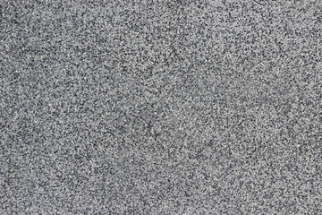Texture of a wall made of white and black crashed stones embedded in concrete