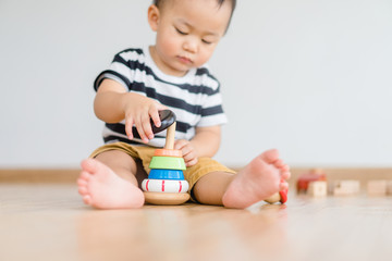 2.5 years baby boy.Little child boy playing stack with colorful wooden toys block alone.Kids play with educational toys at home.Day care and Kindergarten school.child development concept.