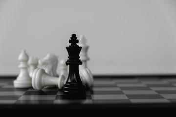 Chess King stand surrounded by enemies. The winner in business competition. Competitiveness and strategy.
