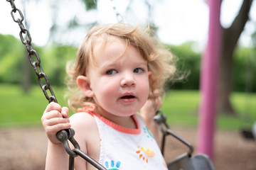 kid playing on swing in summer - soft focus effect
