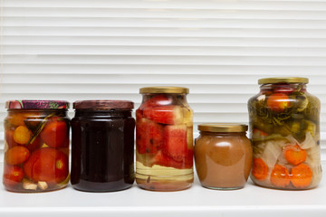 Homemade canned food in glass jars on a white background. Pickled organic food.