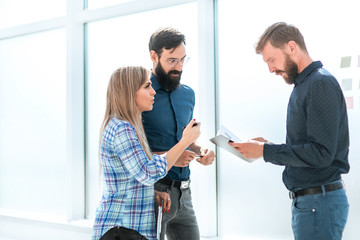 employees discussing current tasks standing in the office