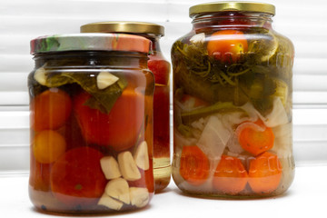 Homemade canned food in glass jars on a white background. Pickled organic food.