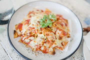 Top view of nachos and cheese.A plate of delicious plain nacho tortilla corn chips with cheese sauce.Mexican appetizer food.
