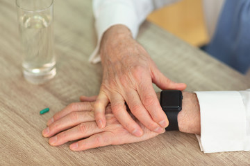 Obraz na płótnie Canvas Senior Man's Hands Checking Smartwatch Before Taking A Pill, Cropped
