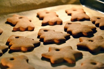 Christmas cookies. Homemade gingerbread cookies in various shapes  on the baking tray. Cookies freshly made at home, golden browned colored cookies before decorating with icing