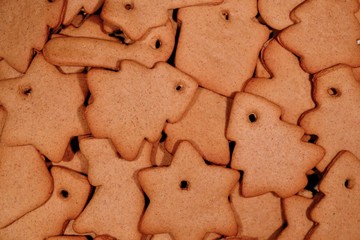 Christmas cookies background. Homemade gingerbread cookies in various shapes freshly made at home, golden browned colored cookies before decorating them with icing.