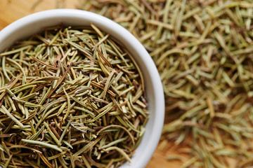 Dried rosemary herb in white dish 