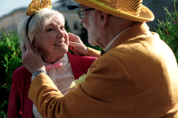 Caring elderly man with wife in funny clothes stock photo