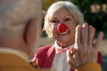 Cheerful old lady in clown costume with man stock photo