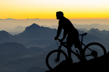 Fototapeta premium Athletic young guy in glasses and a helmet looks into the distance. Toned panoramic image.