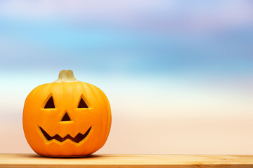 Halloween holiday concept.Jack o lantern pumpkin on black background decor on wooden table with starry night light.Copy space.