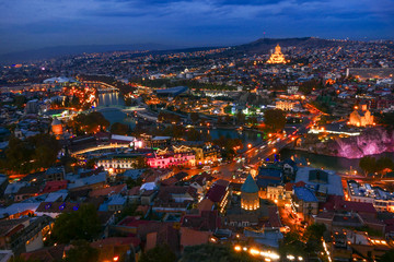 Fototapeta na wymiar Tbilisi, Georgia The city at dusk and the Holy Trinity Cathedral of Tbilisi in the background.