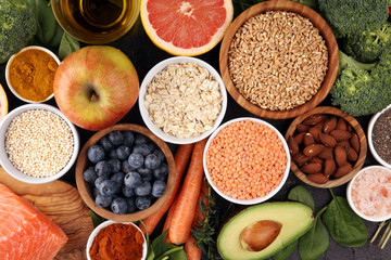 Healthy food clean eating selection: fish, fruit, vegetable, cereal, leaf vegetable on rustic background