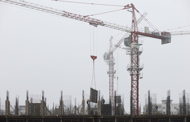 construction of a building with cranes in fog