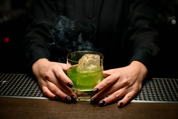 Close-up of smoking cocktail in bartender's hands