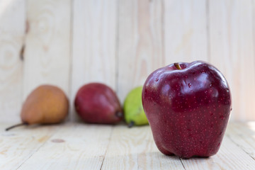single red apple with pear on wooden background