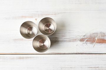 Stainless steel piles for alcohol on a wooden background.