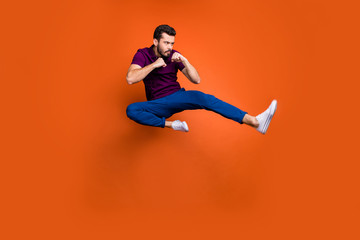Fototapeta na wymiar Full length body size profile side photo of serious confident man in blue trousers white sneakers kicking his leg forward to protect himself isolated vivid color background