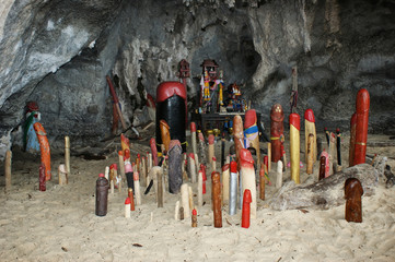 Traditional penis figures in a dark cave. Wooden penis in Princess cave (Phra Nang Shrine Temple).