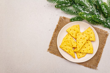 Festive cheese crackers, New Year snack concept. Cookies, fir tree branch, artificial snow,...