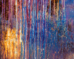 Texture of iron metal painted multicolored red yellow peeling paint of old battered scratched cracked ancient rusty metal sheet wall with corrosion. The background. Paint flows down iron.