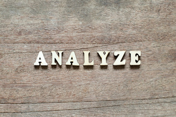 Letter block in word analyze on wood background