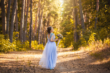 happy bride with a bouquet is walking the green park