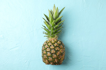 Pineapple on blue background, space for text. Juicy fruit